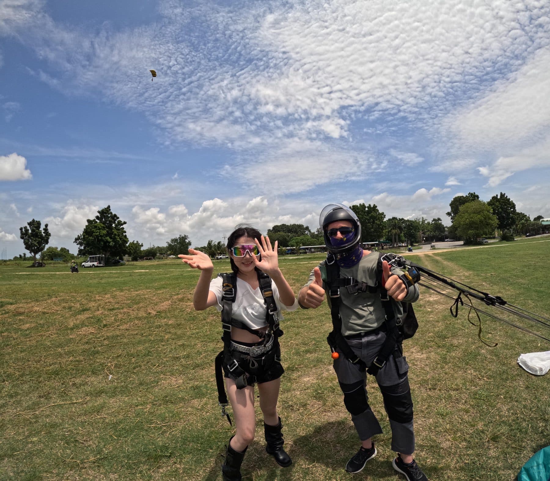 Passenger and instructor waving on the landing field after the jump