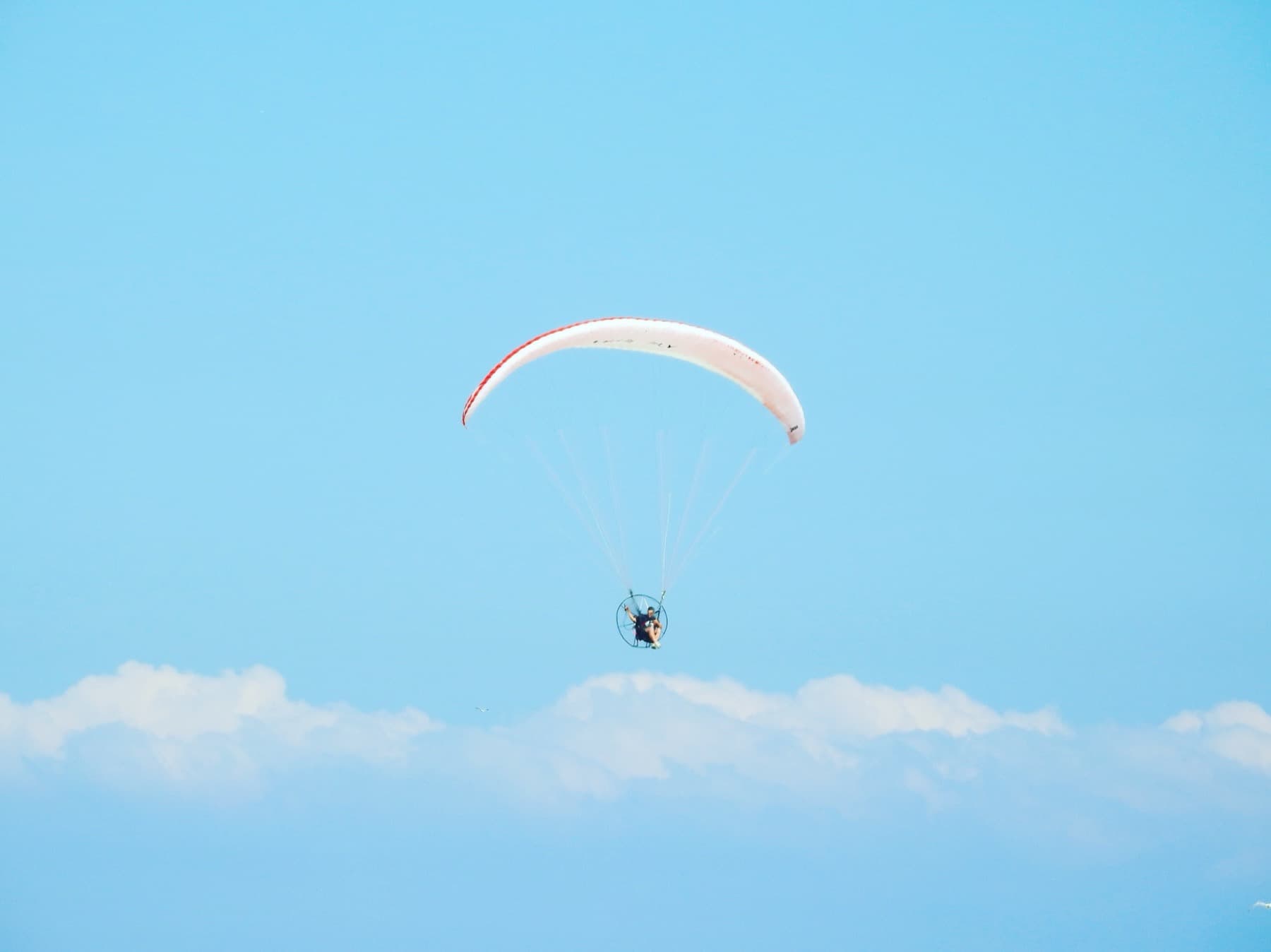 A canopy flying under broken cloud, seen from below